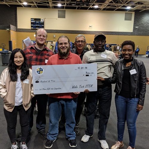 group of engineering students holding large check