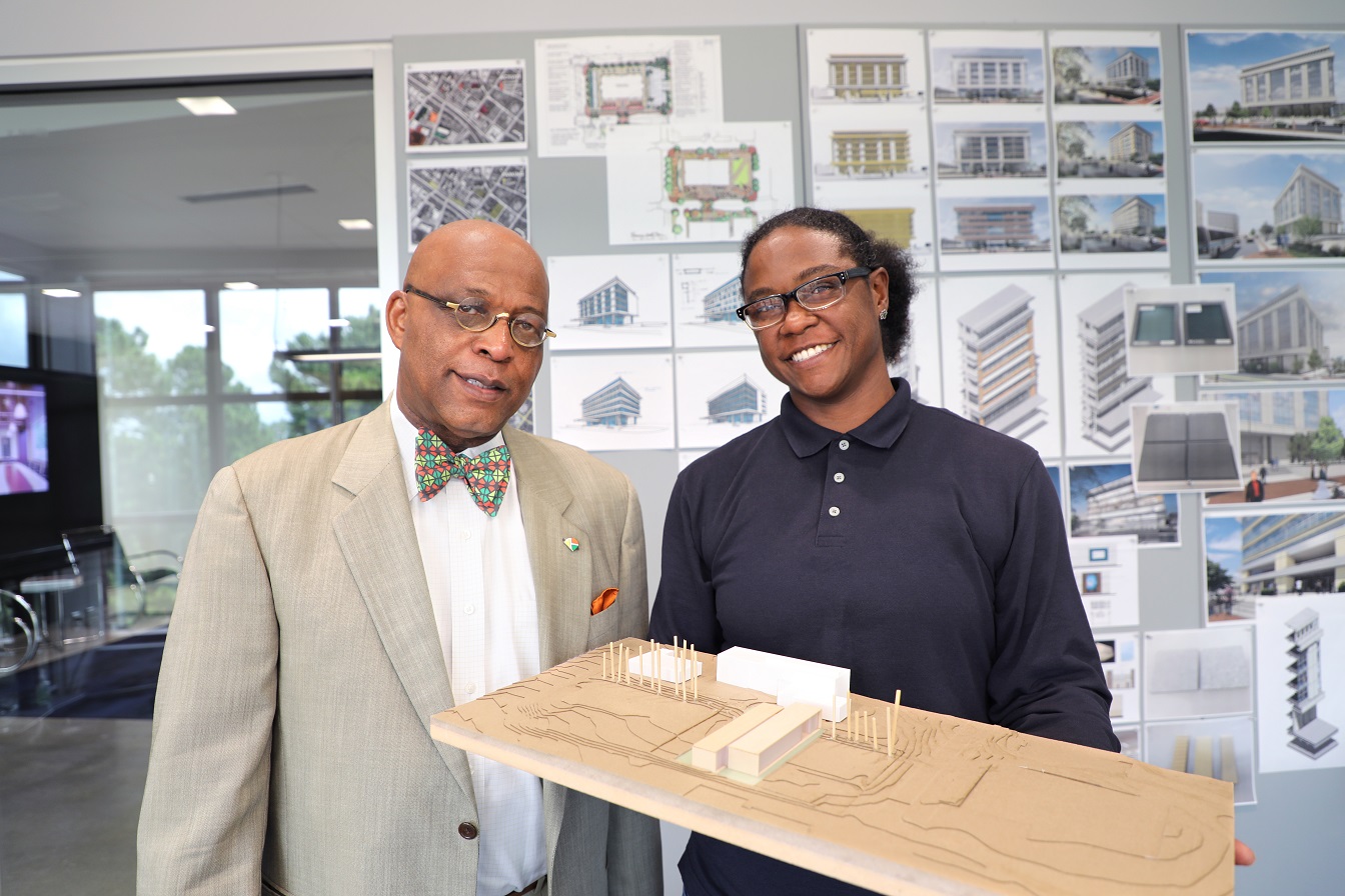 Kevin Montgomery and Carmen Williams holding future model of campus and smiling 