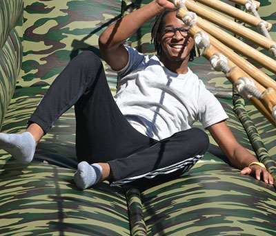 laughing student after falling off horizontal bamboo and rope ladder challenge 