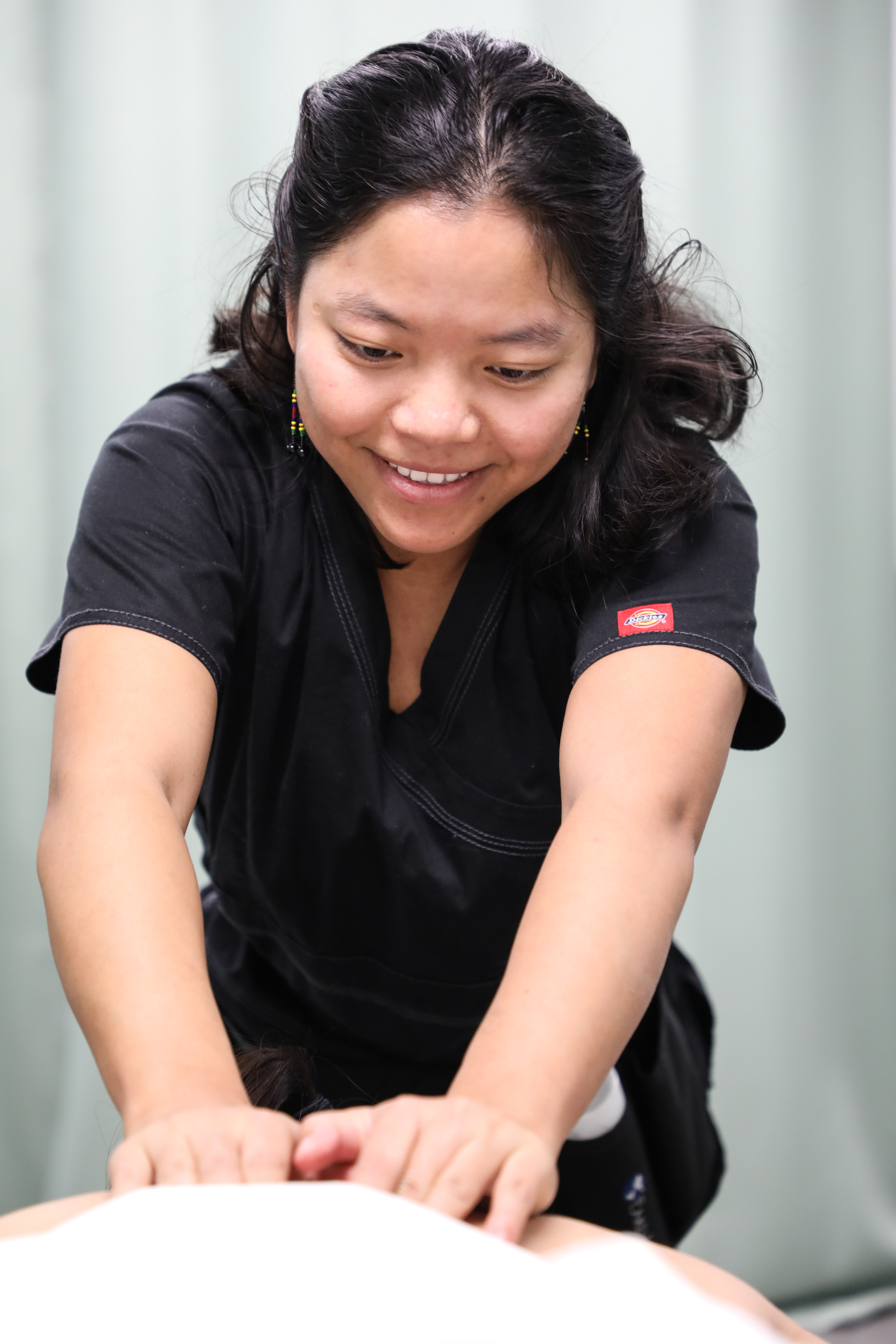 student massaging a person in clinic