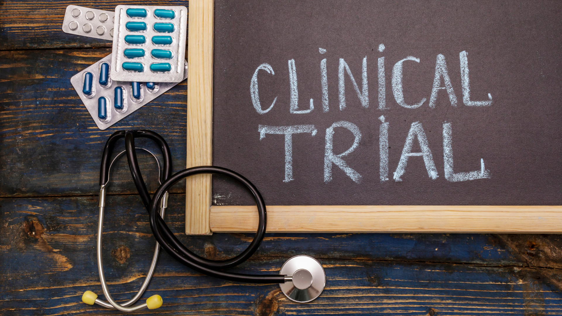 chalkboard that says clinical trials and pills around it