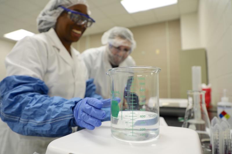 two students performing an experiment in lab coats
