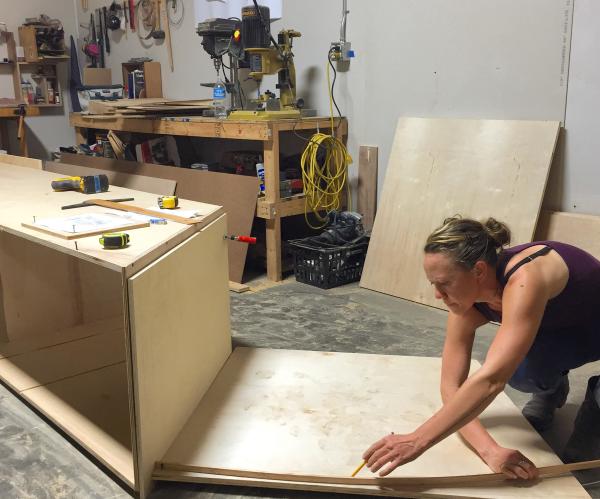 person on floor working on cabinetry