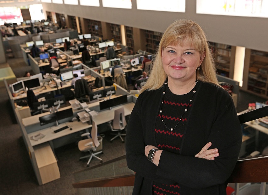 robyn standing in front of newsroom with arms crossed