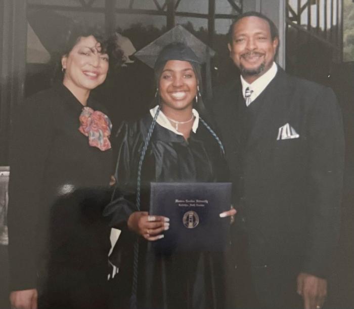 three people smiling at camera at graduation
