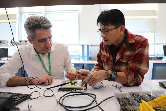 two people looking at electronic device on table
