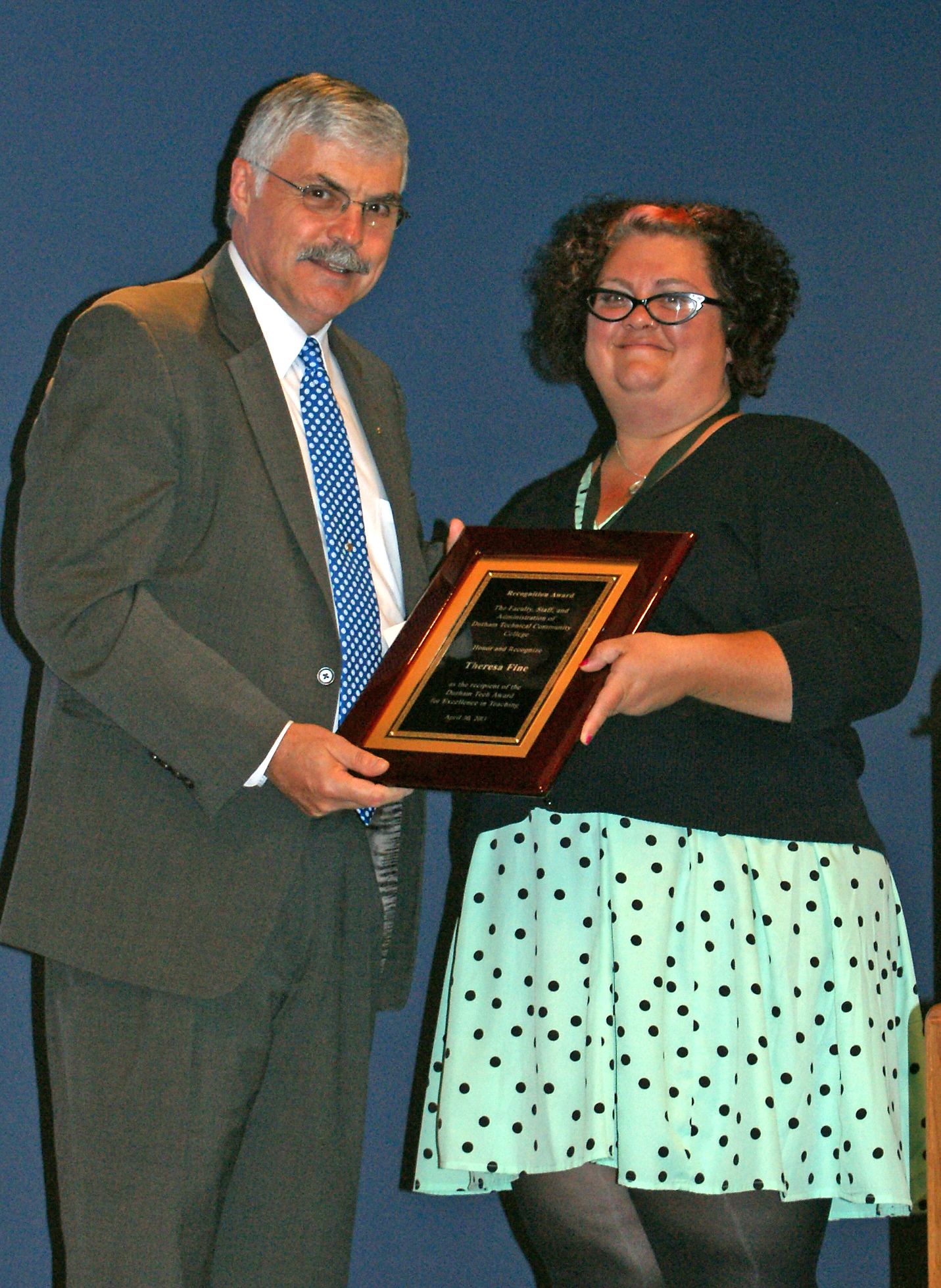 Theresa, holding plaque, poses with President Ingram