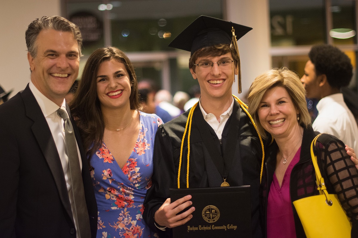family photo after graduation with student in cap and gown in the middle 