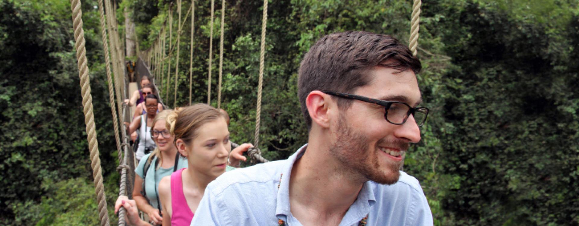 Travel Abroad students walking across rope bridge in Africa.