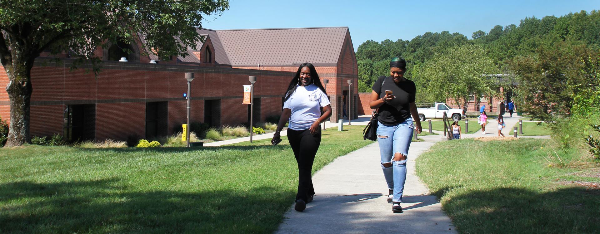 two students walking on through the main campus quad