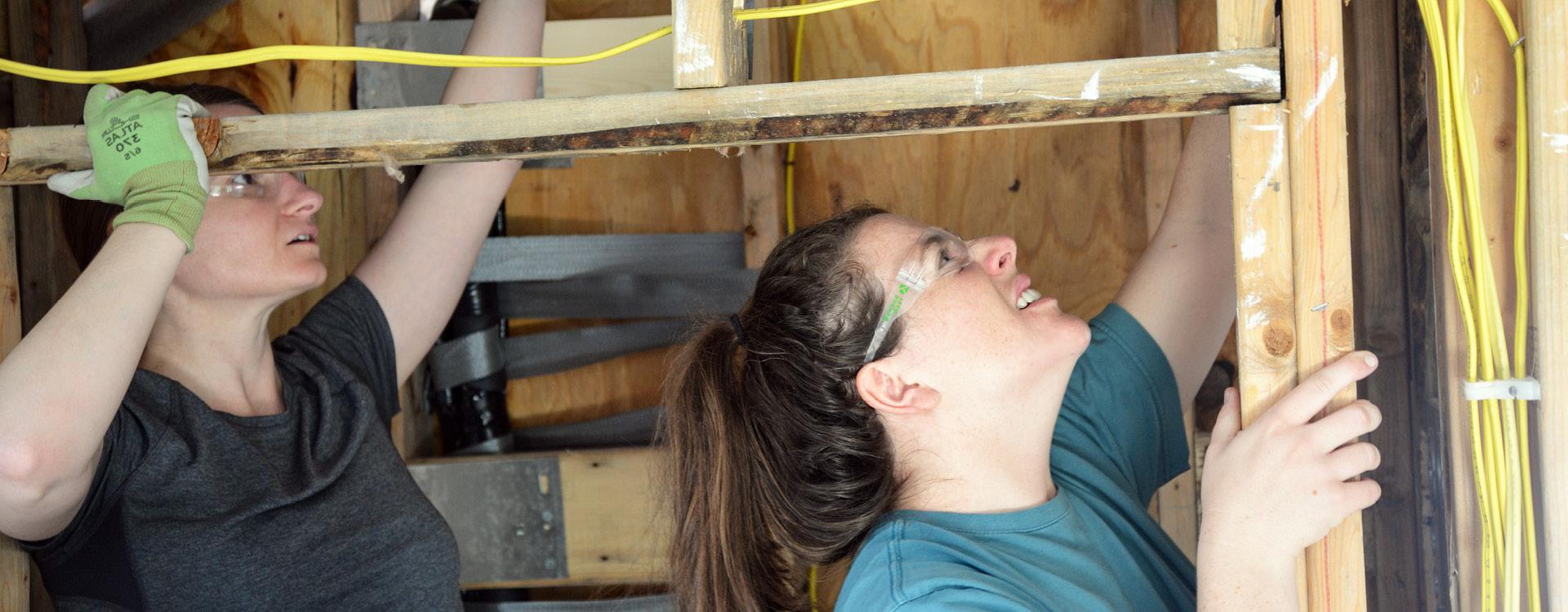 construction students work on shoring up a support beam