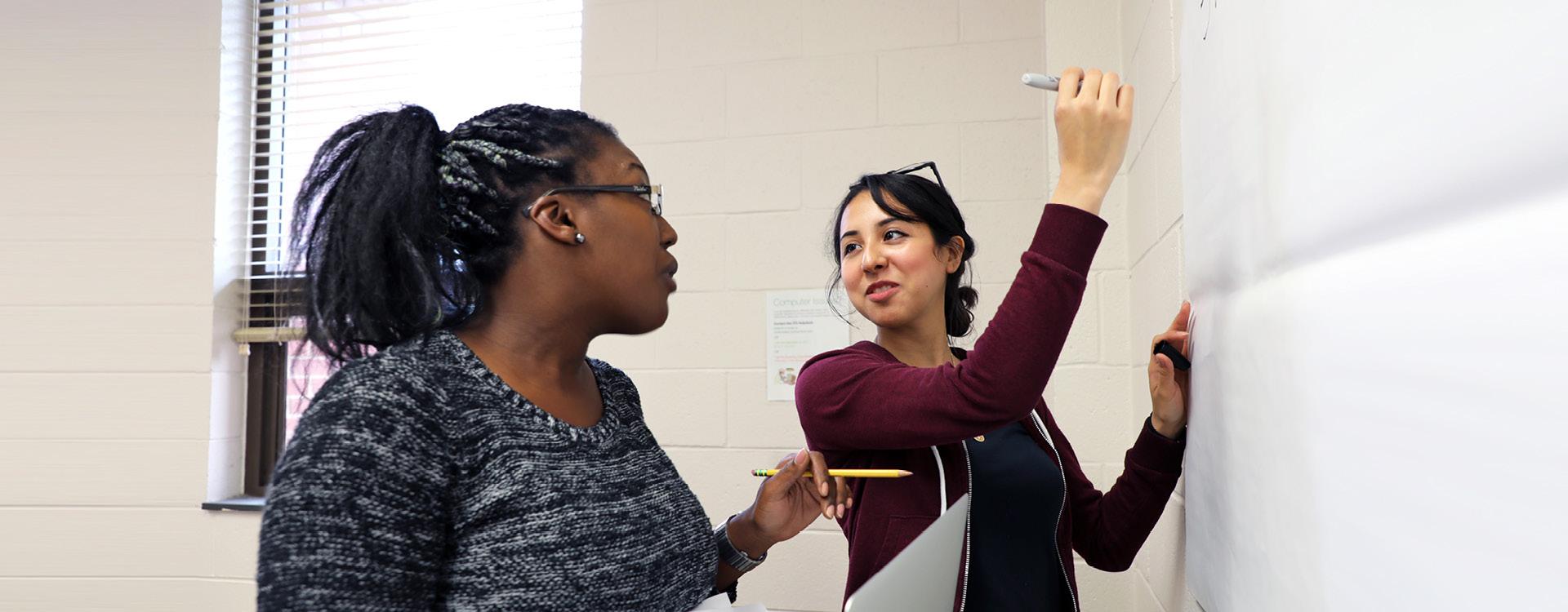 marketing students make list on large paper for a classroom assignment