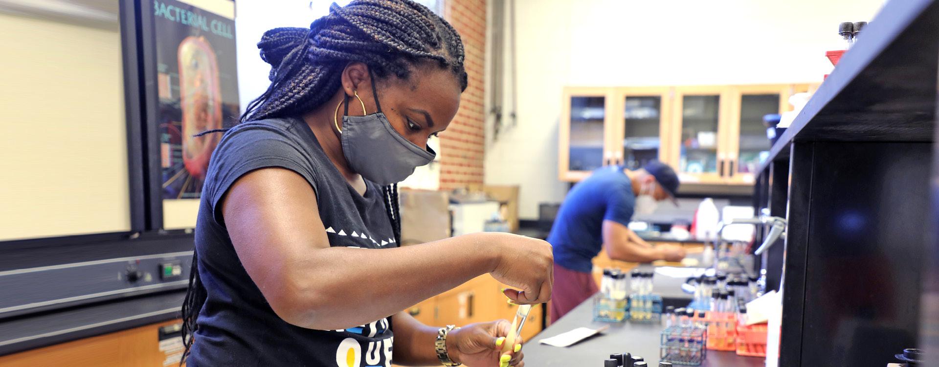 Students wearing masks working with test tubes in chemistry lab
