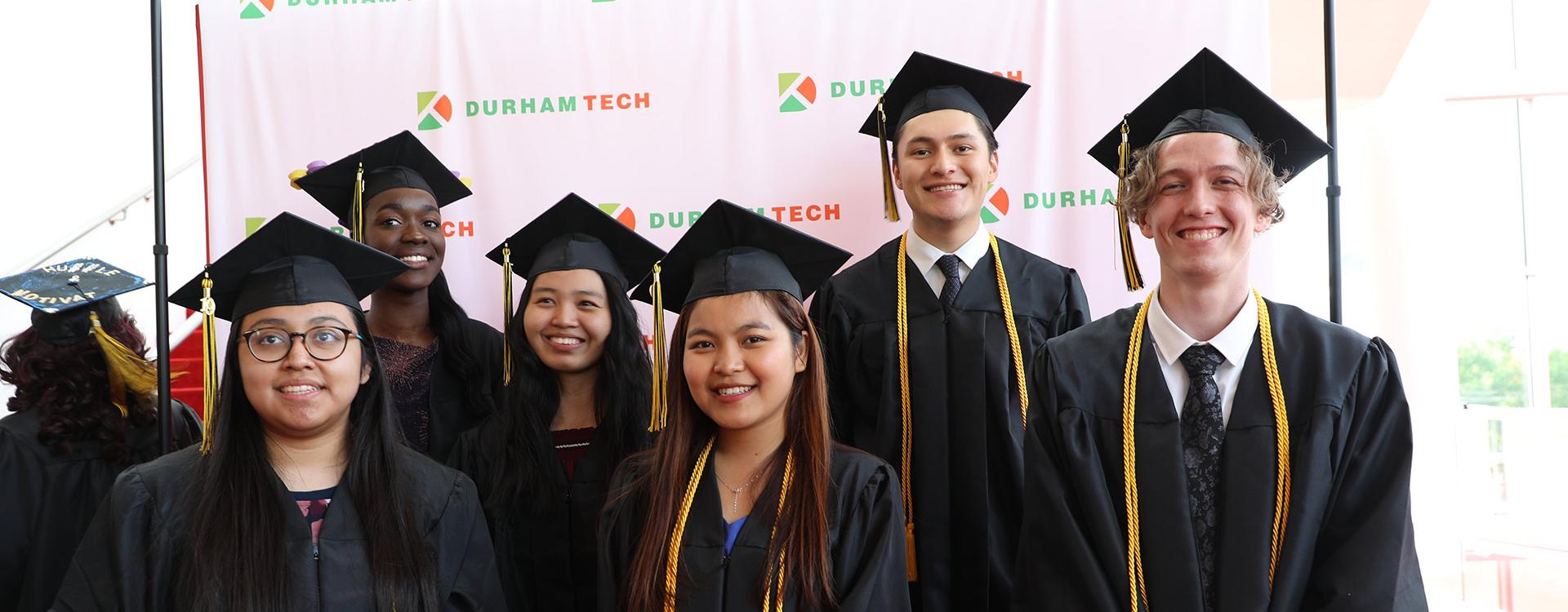 group of students in graduation regalia pose at commencement