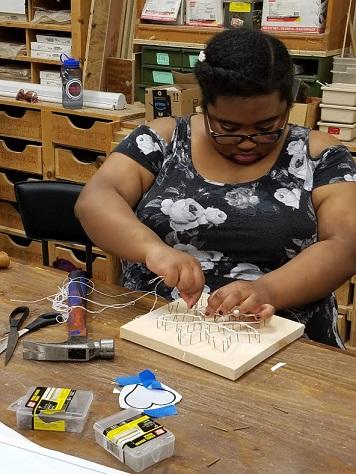 student making string art