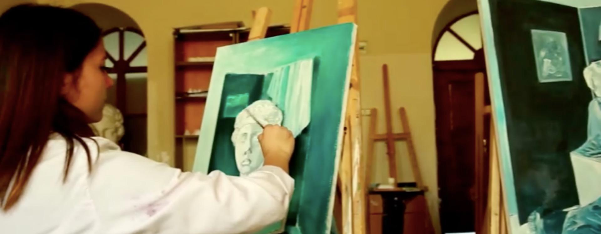 art student painting an image of a head bust on a canvas mounted on an easel