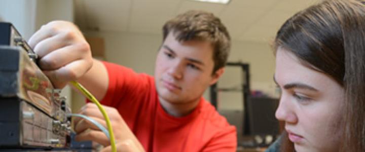 IT students working on configuring a server with cables