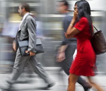 Busy woman on the cell phone walking down the street