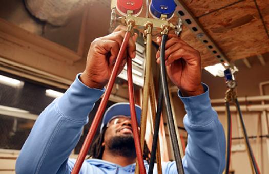 plumbing student adjusting valves and hoses