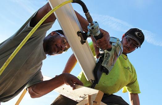 carpentry students use nail gun to secure wood brace