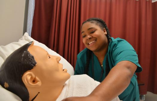 student reaching over mannequin