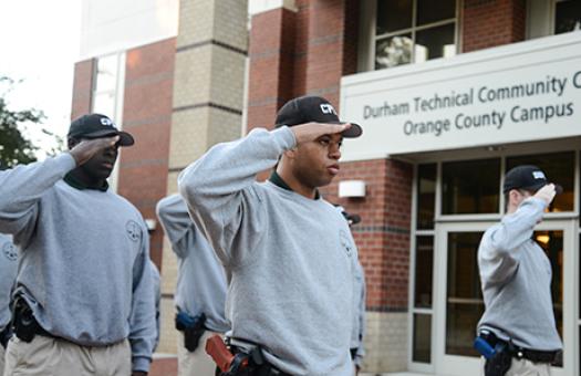 Basic Law enforcement students wearing sidearms salute the flag each morning