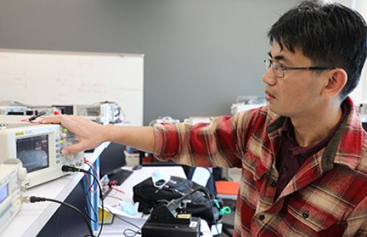 student working on equipment in electronics engineering lab