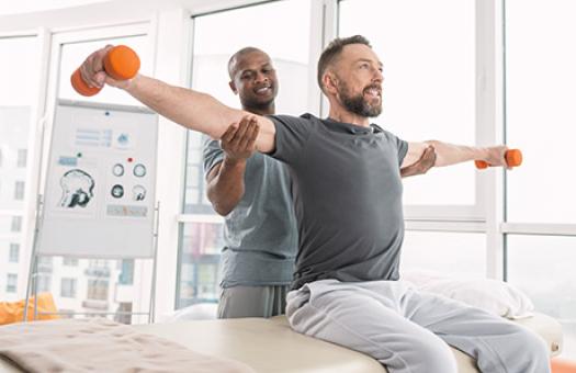 therapist positions athletes arms while lifting weights