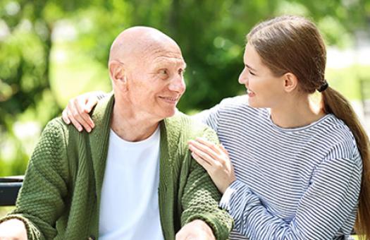supportive moment with younger family member looking after an older family member using a walker