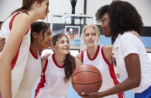 female basketball coach planning strategy with team members