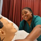student reaching over mannequin
