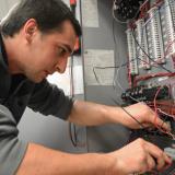 student screwing wires into an electrical board
