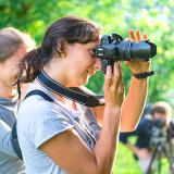 students using professional looking cameras to photograph something offscreen 
