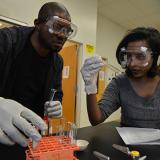 Male and female students performing chemistry experiment with test tubes
