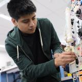biomedical equipment repair student works on sophisticated medical equipment with tubes and dials