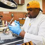 student in dental lab works on carving dentures