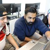 information technology students looking at computer screen