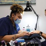 students practice their manicuring skills in lab class