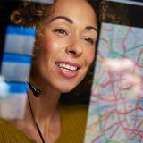 person wearing headset in front of a computer screen with a map displayed