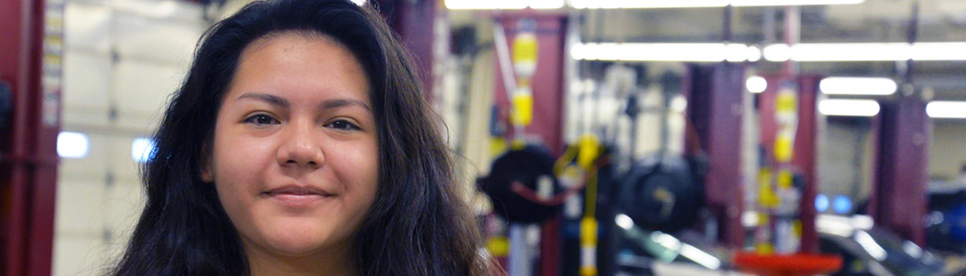 Student standing in automotive garage on main campus. 