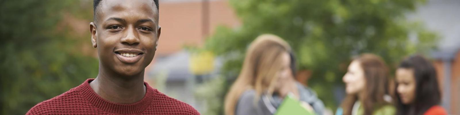 smiling student with other students talking in background