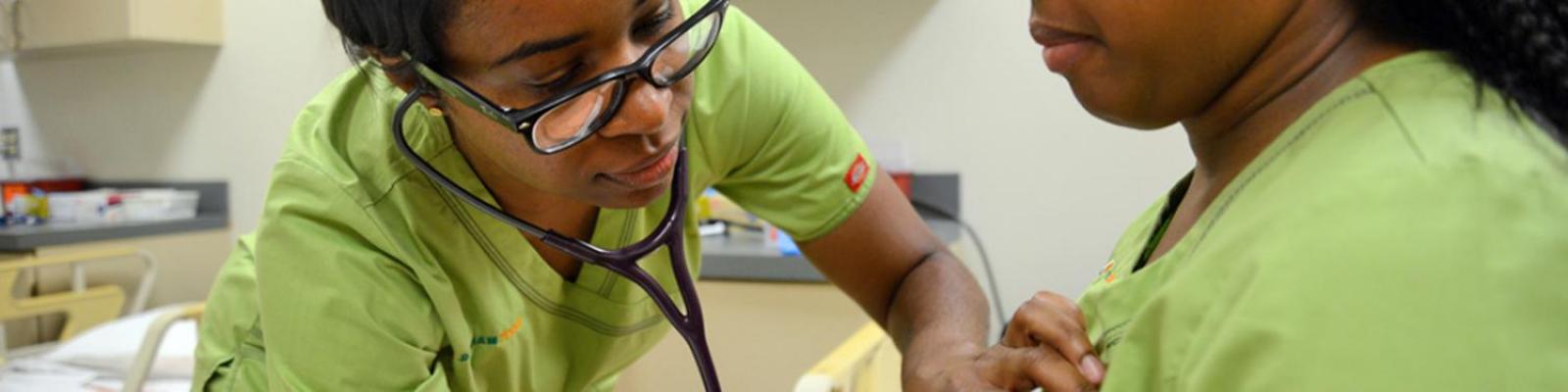 Student listening to another student's heart with stethescope